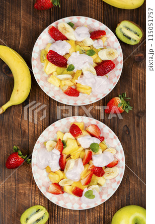 Fruit salad with yogurt on a plate. 115051757