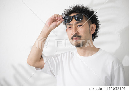 太陽が眩しいのでサングラスをかける男性 眉間にしわを寄せる 太陽が眩しいのでサングラスをかける男性 眉間にしわを寄せる 115052101