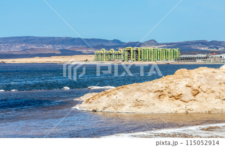Lac Assal salt lake waters with salt extraction factory in the background, the lowest point of Africa, Tadjourah Region, Djibouti 115052914