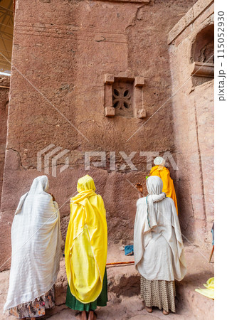 Women pilgrims gathered for mass service at the walls of rock hewn monolithic ortodox church of Bete Maryam, Lalibela, Amhara Region, Ethiopia. 115052930