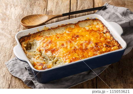 Homemade Cheesy Hashbrown Casserole with Potatoes and Cream closeup in the baking dish. Horizontal Homemade Cheesy Hashbrown Casserole with Potatoes and Cream closeup in the baking dish. Horizontal 115053621