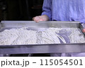 手打ちそば体験でそば粉を切っている女性 115054501