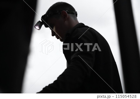 Copper mine worker. Rescuer man with flashlight. War in Ukraine. Ukrainian miner in action. Gold mine rescue Copper mine worker. Rescuer man with flashlight. War in Ukraine. Ukrainian miner in action. Gold mine rescue 115054528