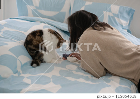 pet care concept with asian woman play with scottish tabby cat on bed with happy feeling 115054619