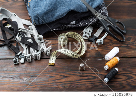 Sewing supplies and materials. Sewing workshop. Clothes and threads on the table. 115056979
