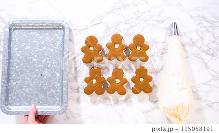 Flat lay. Gingerbread cookies await their second halves on a marble surface, each meticulously piped with buttercream to craft delightful sandwich treats. The precision of the piping adds a festive Flat lay. Gingerbread cookies await their second halves on a marble surface, each meticulously piped with buttercream to craft delightful sandwich treats. The precision of the piping adds a festive 115058191