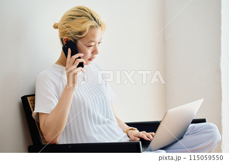 自宅でスマホを操作する女性 115059550