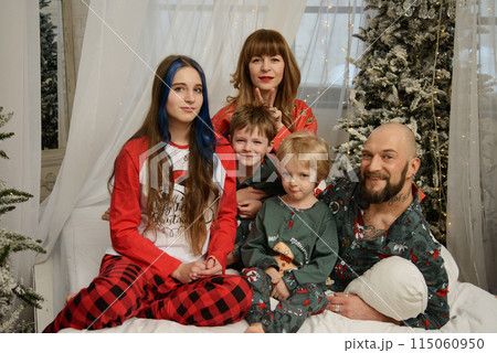 A large family with children posing in pajamas in New Year's locations. A large family with children posing in pajamas in New Year's locations. 115060950