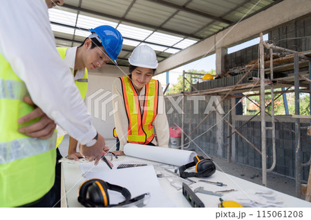 Team of engineer reviewing discussion blueprint at construction site, collaborative planning 115061208