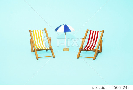 Beach relaxation and vacation concept. Toy sun lounger and umbrella on blue colorful paper background. 115061242