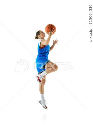 Side view portrait of professional female basketball player jumping with ball ready to score goal against white studio background. 115064336