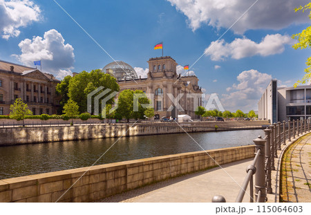 Glass dome and waving German national flags on the Reichstag building. Berlin. 115064603