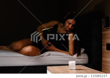 Sad young woman wearing nighty shirt suffering from menstrual pain, feeling sick to her stomach, holding belly. Girl having abdominal cramps during period and lying down on bed at home Sad young woman wearing nighty shirt suffering from menstrual pain, feeling sick to her stomach, holding belly. Girl having abdominal cramps during period and lying down on bed at home 115065237