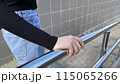 Close up photo of woman hand holding onto steel handrail of staircase on the street, grabbing the handrail 115065266