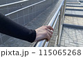 Girl hand holds metal handrail on street ramp for balance, safe movement on the street 115065268