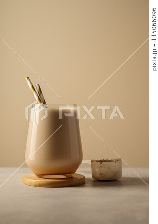 Healthy chocolate protein shake drink with straw, and protein powder Healthy chocolate protein shake drink with straw, and protein powder 115066096