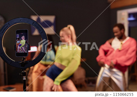 Trendy dance crew recording videos for social media or livestream with focus on ring light in foreground copy space Trendy dance crew recording videos for social media or livestream with focus on ring light in foreground copy space 115066255