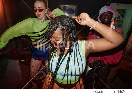 Dynamic high angle shot of multiethnic group of young people dancing with camera flash trendy Black young woman in foreground 115066262