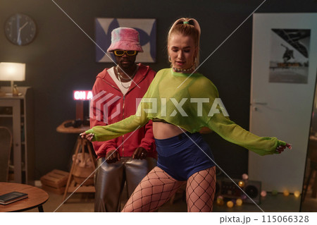 Portrait of two dance performers wearing colorful outfits dancing indoors recording content videos for social media 115066328