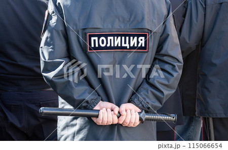 Russian policeman in the uniform with inscription Police and with truncheon Russian policeman in the uniform with inscription Police and with truncheon 115066654