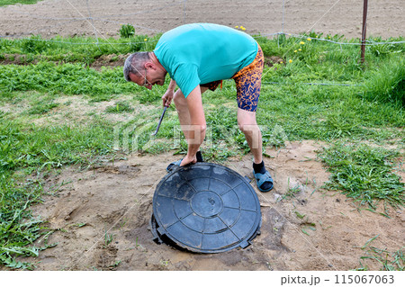Polymer composite manhole cover is removed from drainage well for maintenance. 115067063