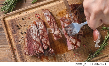 Chef slicing freshly grilled juicy beef steak Chef slicing freshly grilled juicy beef steak 115067671