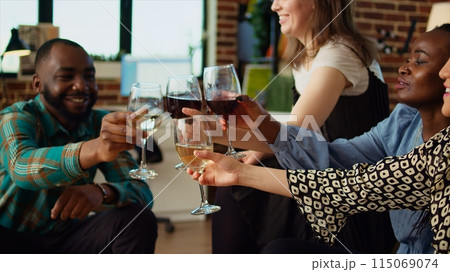 BIPOC group of friends talking with each other in stylish apartment living room, gathered together to celebrate festive event. Best mates socializing at home, enjoying wine and appetizers 115069074