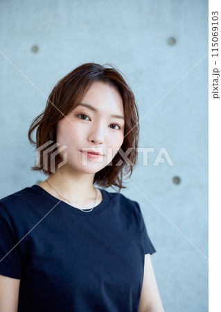 コンクリート背景に椅子に座った女性 115069103