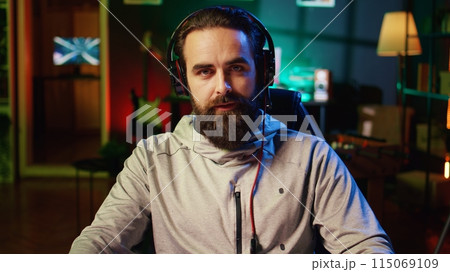 Streamer greeting audience, filming tutorial on how to defeat enemies in multiplayer game, zoom out shot. Close up on professional gamer playing videogame, teaching fans esports strategies 115069109