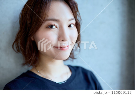 コンクリート背景に立つ女性のポートレート コンクリート背景に立つ女性のポートレート 115069113