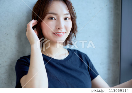 コンクリート背景に立つ女性のポートレート 115069114