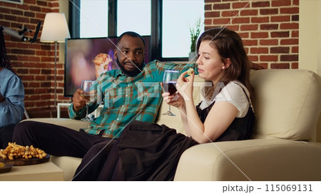 Company employees celebrating business success at work, gathered at home to toast wine drinks for their accomplishments, throwing house party in stylish living room 115069131