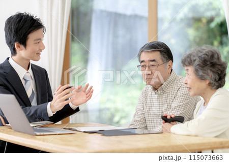 シニア夫婦と話す訪問営業の男性 115073663