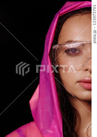Woman wearing pink raincoat and large clear garden or safety glasses Woman wearing pink raincoat and large clear garden or safety glasses 115073701