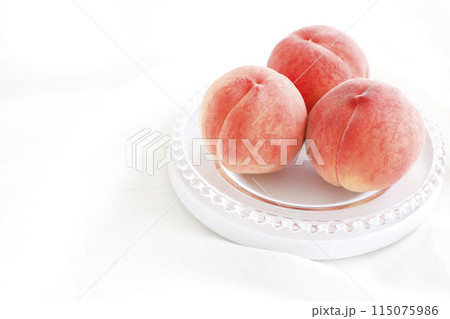 皿に盛られた美味しそうな桃　ドレープ布の白背景 115075986