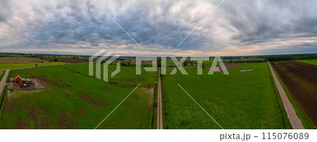 Aerial view of countryside with fields, roads, cloudy sky, showcasing landscape and farming Aerial view of countryside with fields, roads, cloudy sky, showcasing landscape and farming 115076089