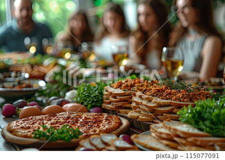 Festive table for celebrating Passover against the background of an Israeli Jewish family celebrating 115077091