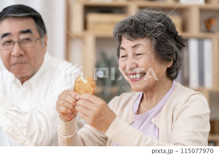 お煎餅を食べるシニア夫婦 お煎餅を食べるシニア夫婦 115077970