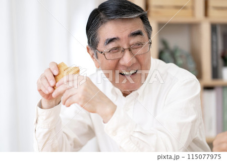 お煎餅を食べるシニア男性 115077975