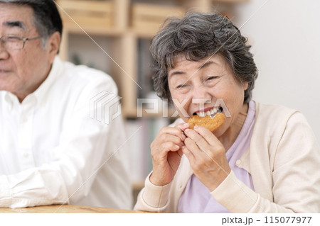 お煎餅を食べるシニア夫婦 115077977