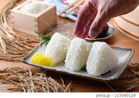 炊き立てのごはんで作ったおにぎり（塩むすび）と枡に盛ったお米と梅干し 115080129