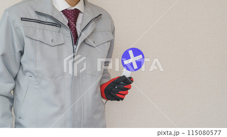 バツ札を持つ作業服の男性｜建設業・製造業などのNG・不正解　イメージ 115080577