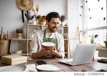 Adult ceramic shop owner using laptop while working in store. 115080741