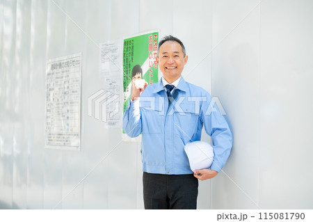 作業服の男性　工事現場　防護壁　ガッツポーズ 115081790