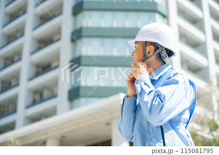 作業服の男性　オフィスビル　見上げる 115081795