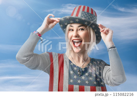 Independence Day. Happy young woman dressed in american flag clothes Independence Day. Happy young woman dressed in american flag clothes against the blue sky. Independence Day. Happy young woman dressed in american flag clothes Independence Day. Happy young woman dressed in american flag clothes against the blue sky. 115082216