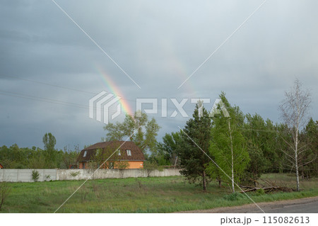【ウクライナ】郊外の森に囲まれた住居越しに見える雨上がりの虹 【ウクライナ】郊外の森に囲まれた住居越しに見える雨上がりの虹 115082613