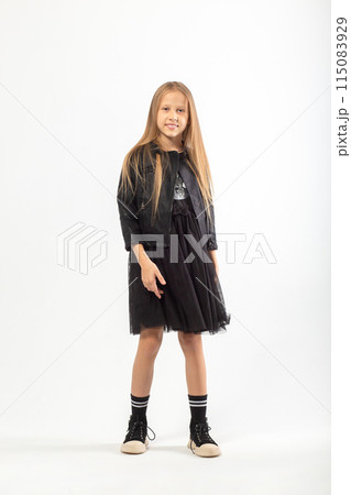 A full-length portrait of a young girl with long brown hair dressed in a hooligan style. 115083929