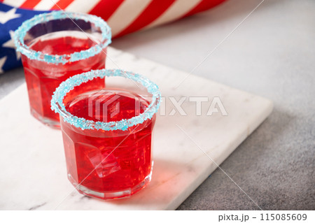 Patriotic red pomegranate margarita cocktail on gray background. Festive beverages for Independence Day July 4th. Close up. Copy space. Rimmed drinks. Patriotic red pomegranate margarita cocktail on gray background. Festive beverages for Independence Day July 4th. Close up. Copy space. Rimmed drinks. 115085609