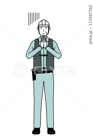 体の前で手を合わせて謝るヘルメットと作業着姿のシニア男性技師 115087362